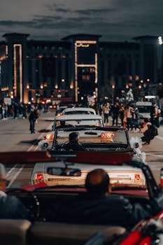 Vintage cars cruising down Ankara's illuminated streets at night, capturing an urban retro vibe.