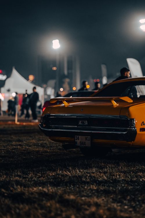 Free Rear view of a classic yellow car at a night festival in Ankara, Türkiye. Stock Photo