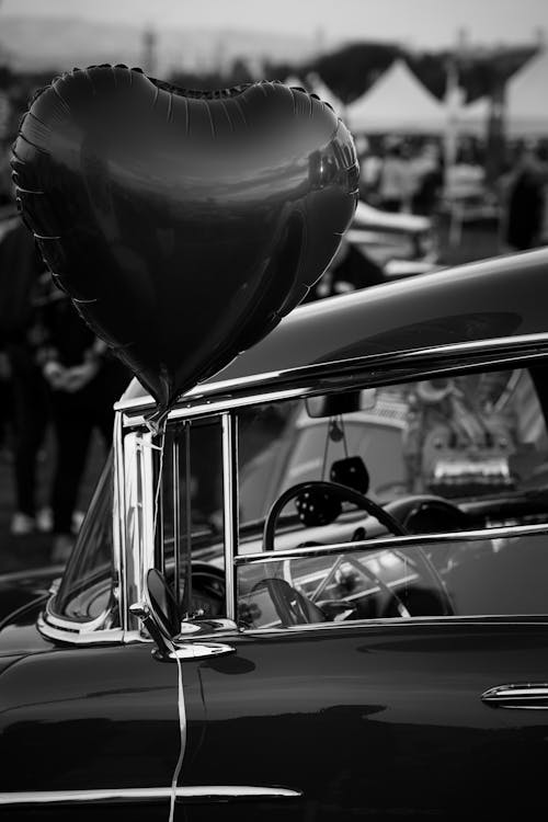 Heart Shaped Balloon by a Vintage Car in Black and White