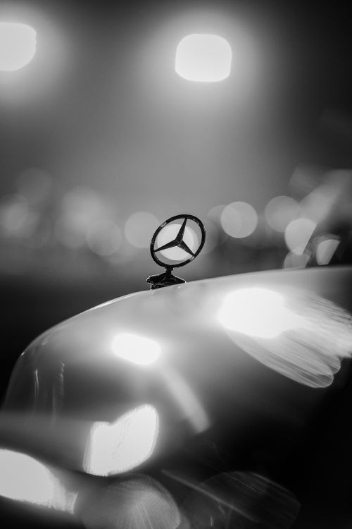 Free Black and white photo of a Mercedes emblem on car hood with bokeh lights, Ankara. Stock Photo