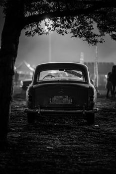 Black and white photo of a vintage car parked outdoors at night in Ankara.