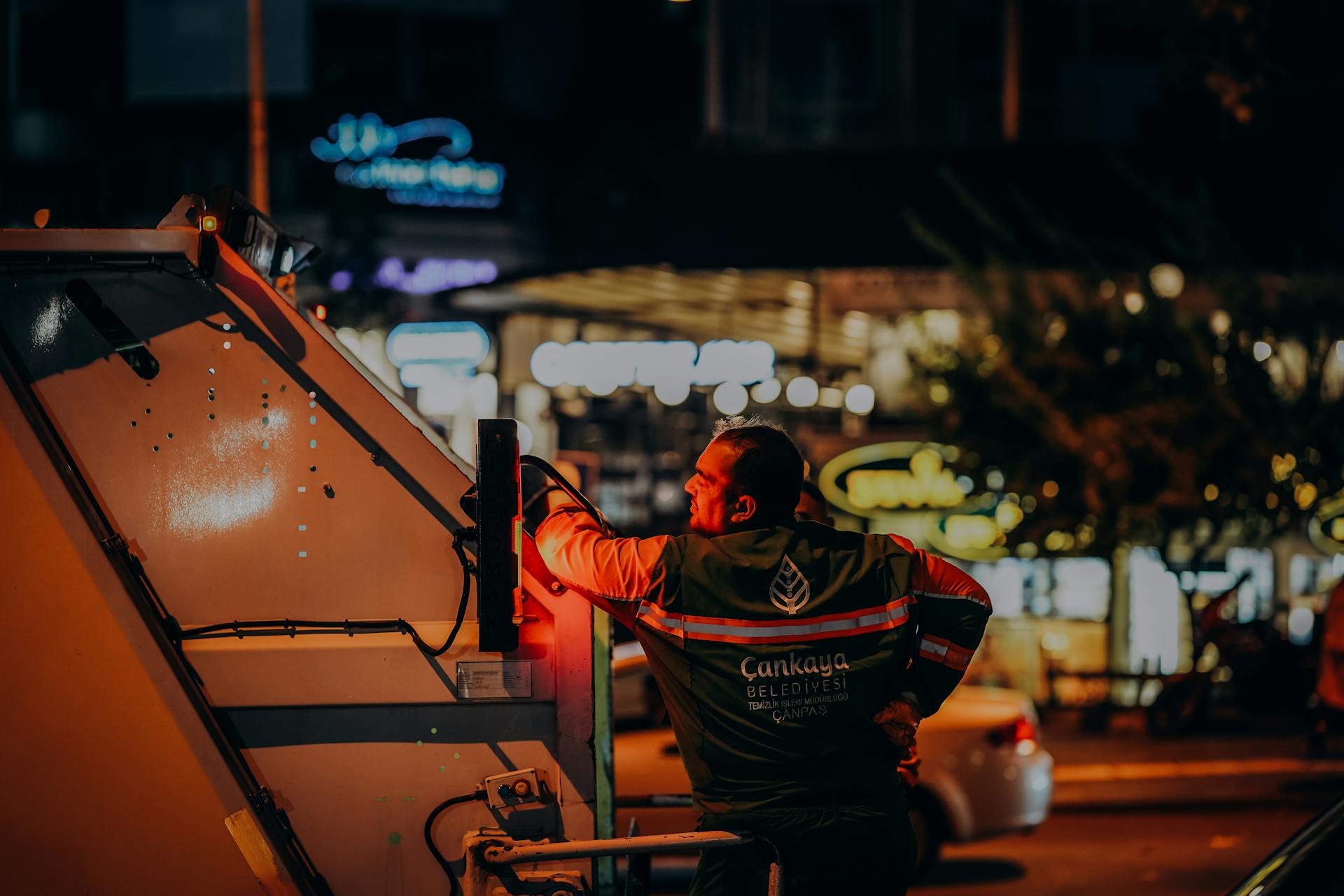Sanitation Worker Leaning on a Garbage Truck