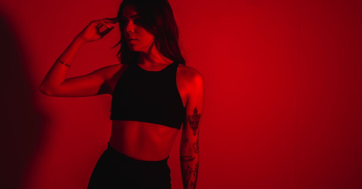 Models Red Background Model with Tattoos on Red Background · Free Stock Photo