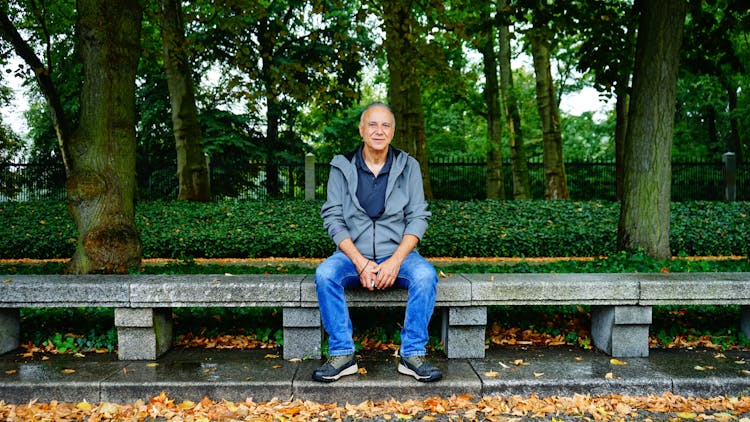 Man Sitting On Bench In Park In Autumn