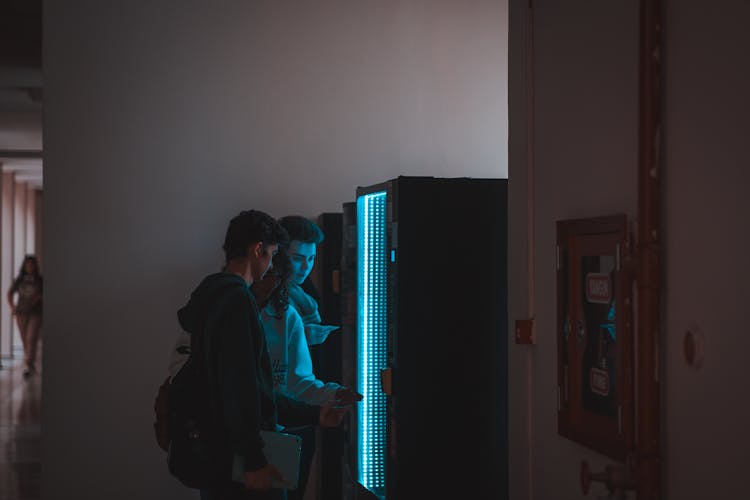 Teenagers By Vending Machine In School Corridor