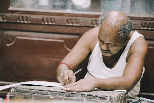 Man Making a Wooden Sculpture in a Workshop 