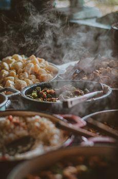 Close-up of a steaming buffet with diverse dishes, showcasing an appetizing variety of food.