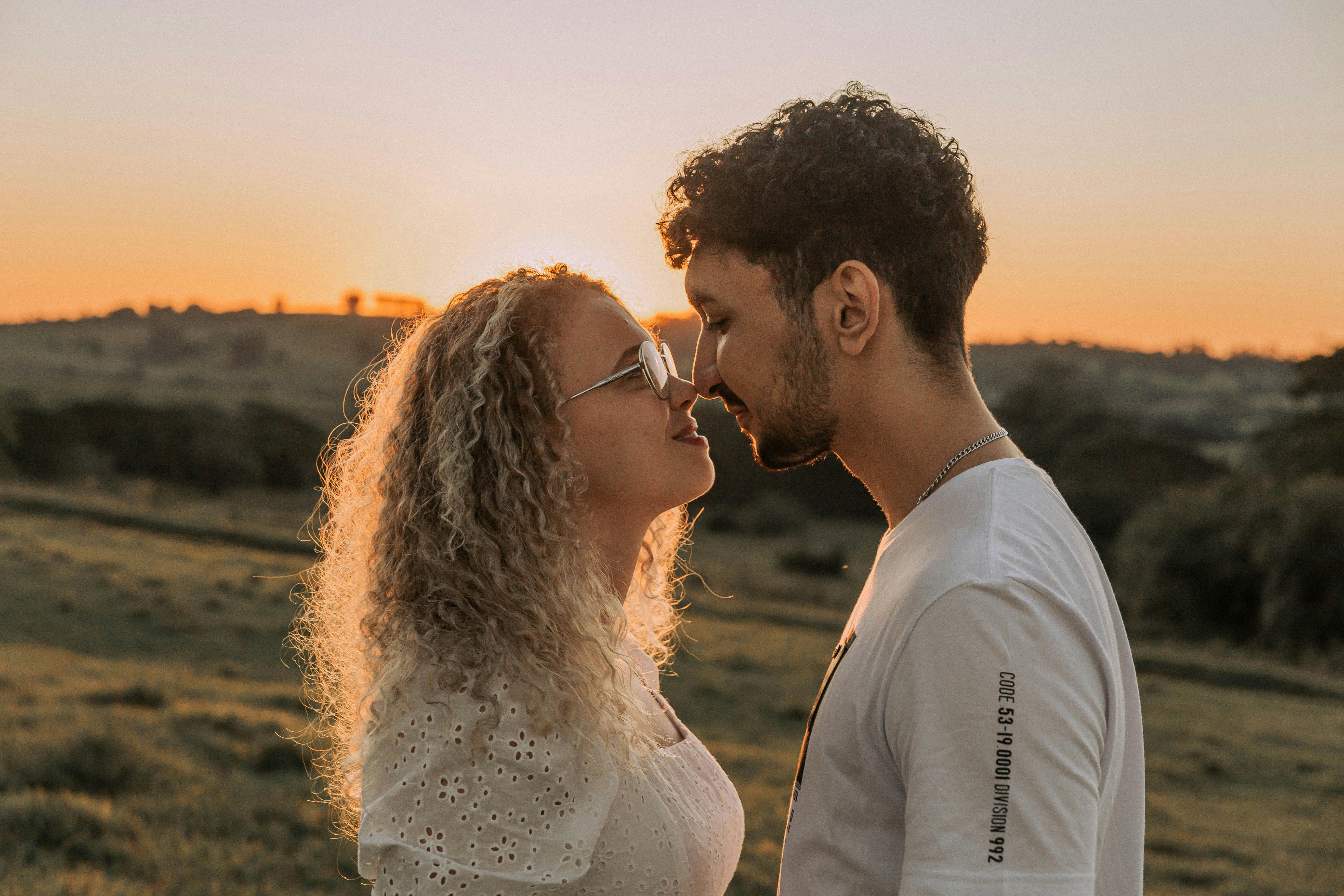 A couple shares an intimate moment in a field during a beautiful sunset in Presidente Prudente, Brazil.