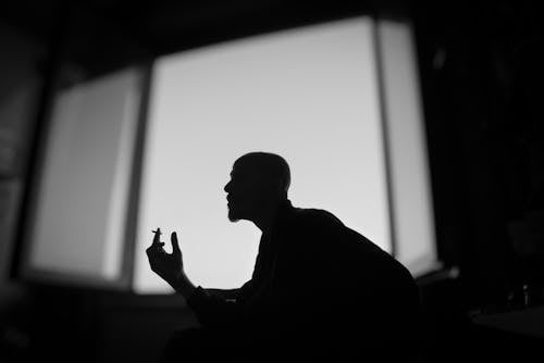 Man Smoking Cigarette in Darkness