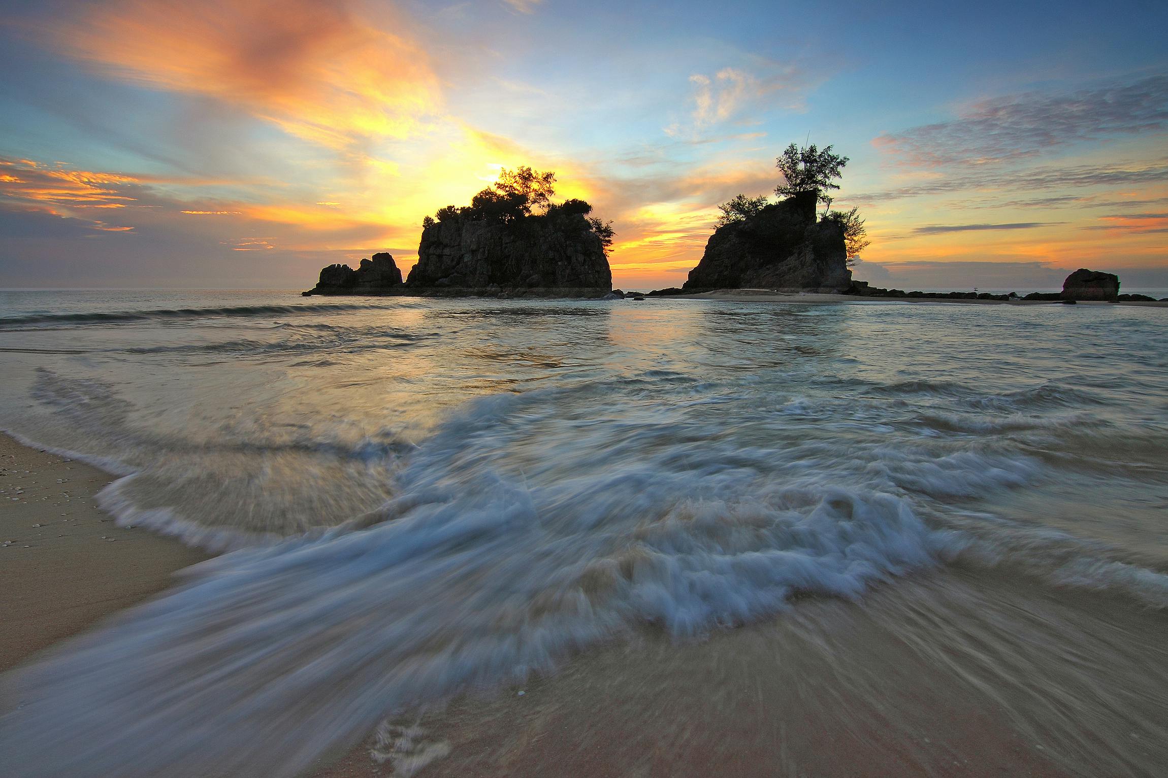 white sand beach next to islets