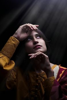 Stunning portrait of a woman looking upwards under dramatic sunbeam lighting, creating a mysterious ambiance.. pexels, stunni