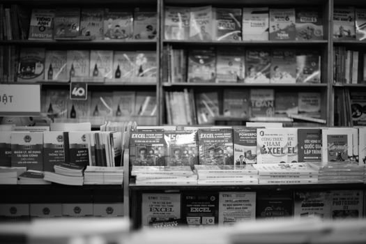 Black and white photo of neatly arranged books on shelves in a bookstore.
