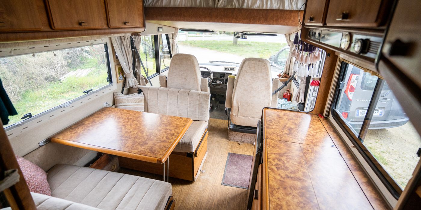 Inside an older motorhome, with wood cabinets and the ceiling running the length of the coach