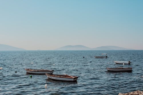 Boats Moored near the Shore with the View of Mountains in the Horizon 