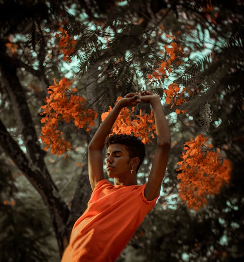 Mise Au Point Peu Profonde Photo De L'homme Qui S'étend Près De Fleurs Orange