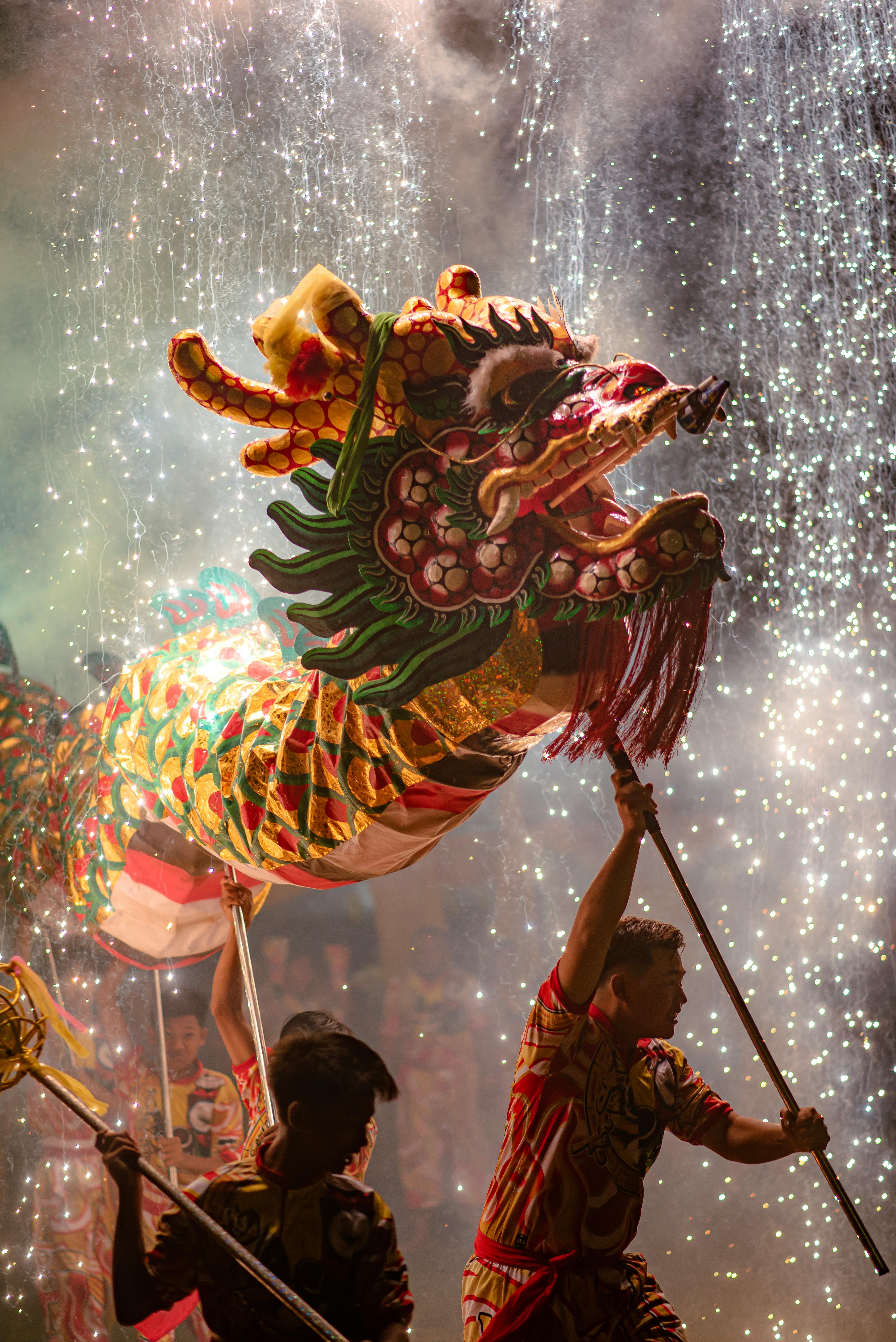 A colorful dragon dance performance amidst fireworks during a night festival, capturing the essence of celebration.