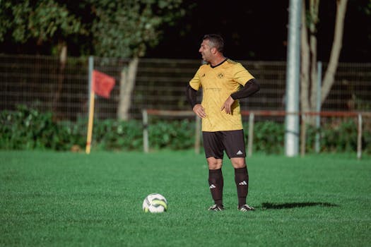 Adult soccer player on a sunny outdoor field preparing for play.