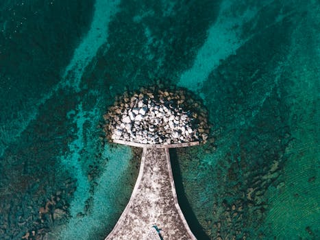 Stunning aerial shot of a pier in Poreč, Croatia, surrounded by clear turquoise water.