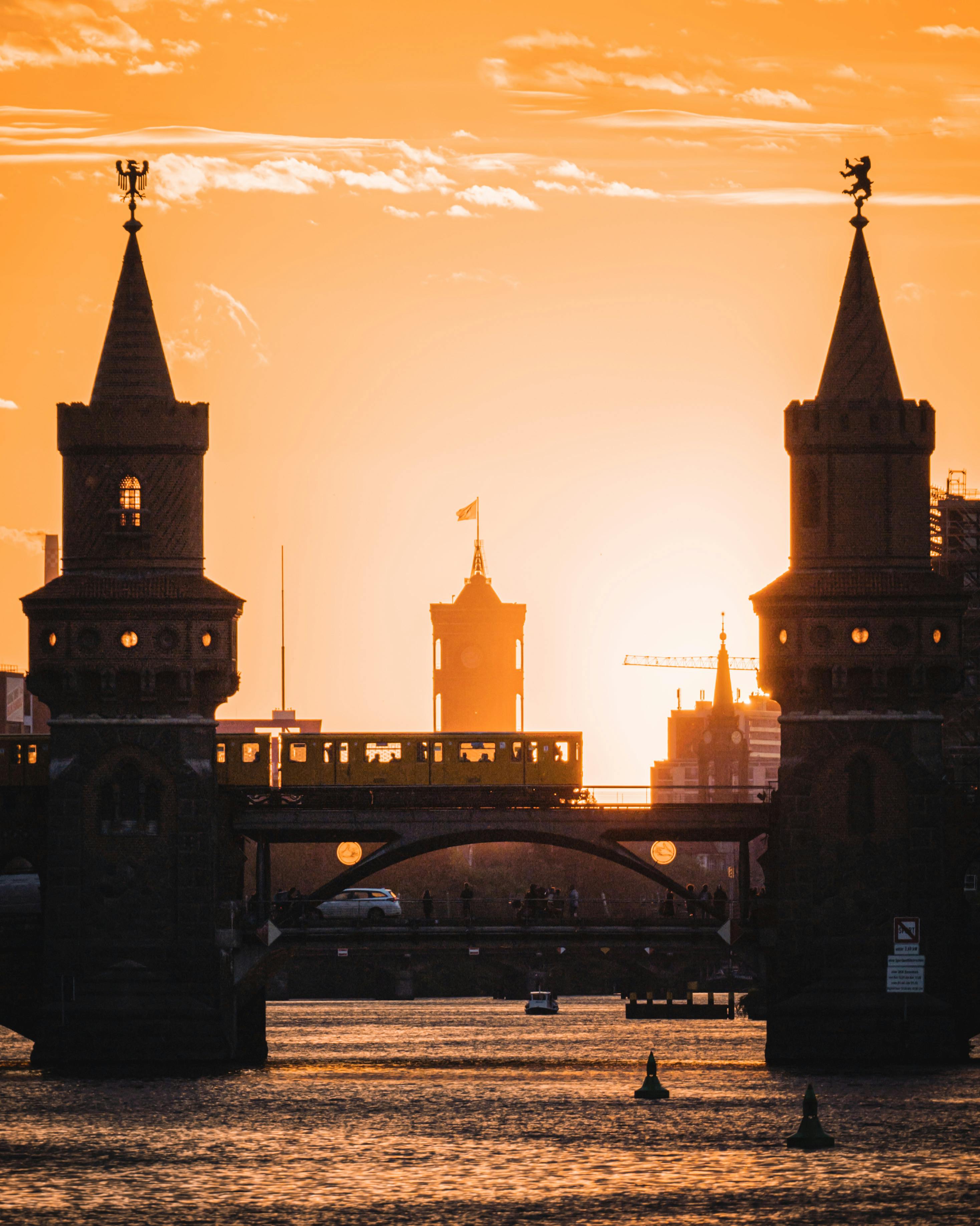 Dramatic sunset behind the iconic Oberbaum Bridge in Berlin, showcasing its silhouette.