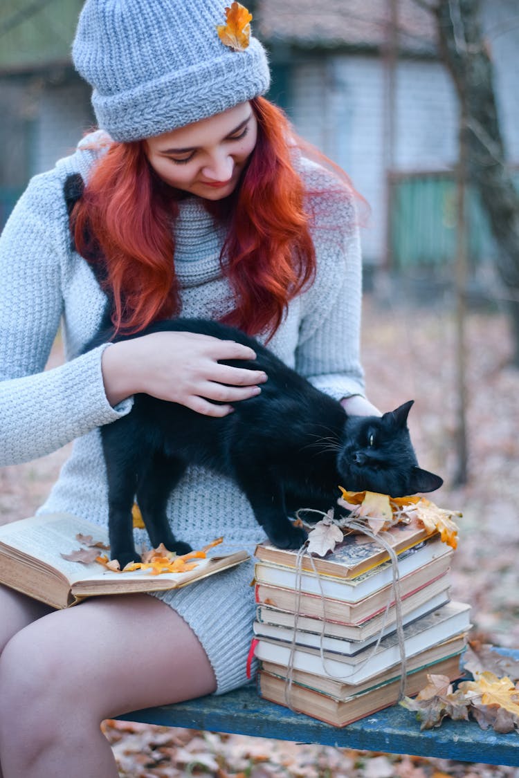 Redhead Woman Sitting With Black Dog And Books