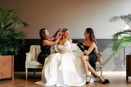 Bridesmaids Adjusting Wedding Dress on Bride