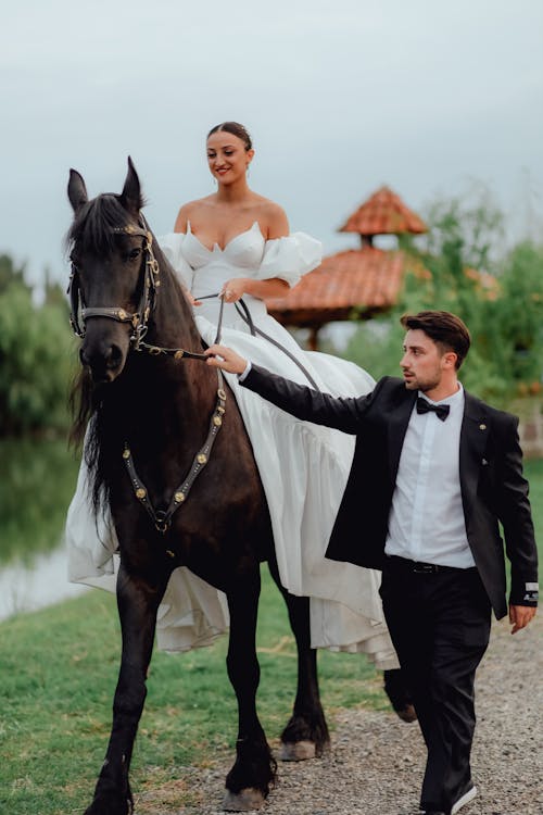 Bridegroom Leading Horse with Bride Sitting on Horse Back