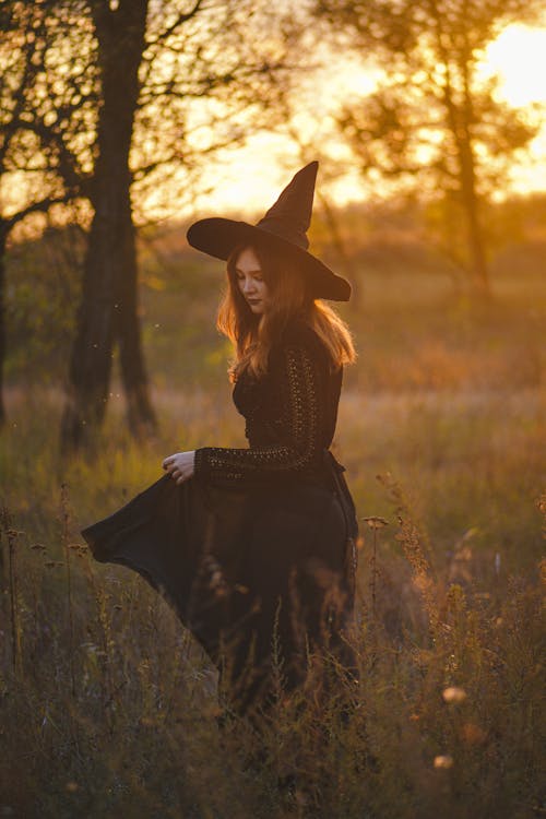 Woman in a Halloween Witch Costume Walking on a Field