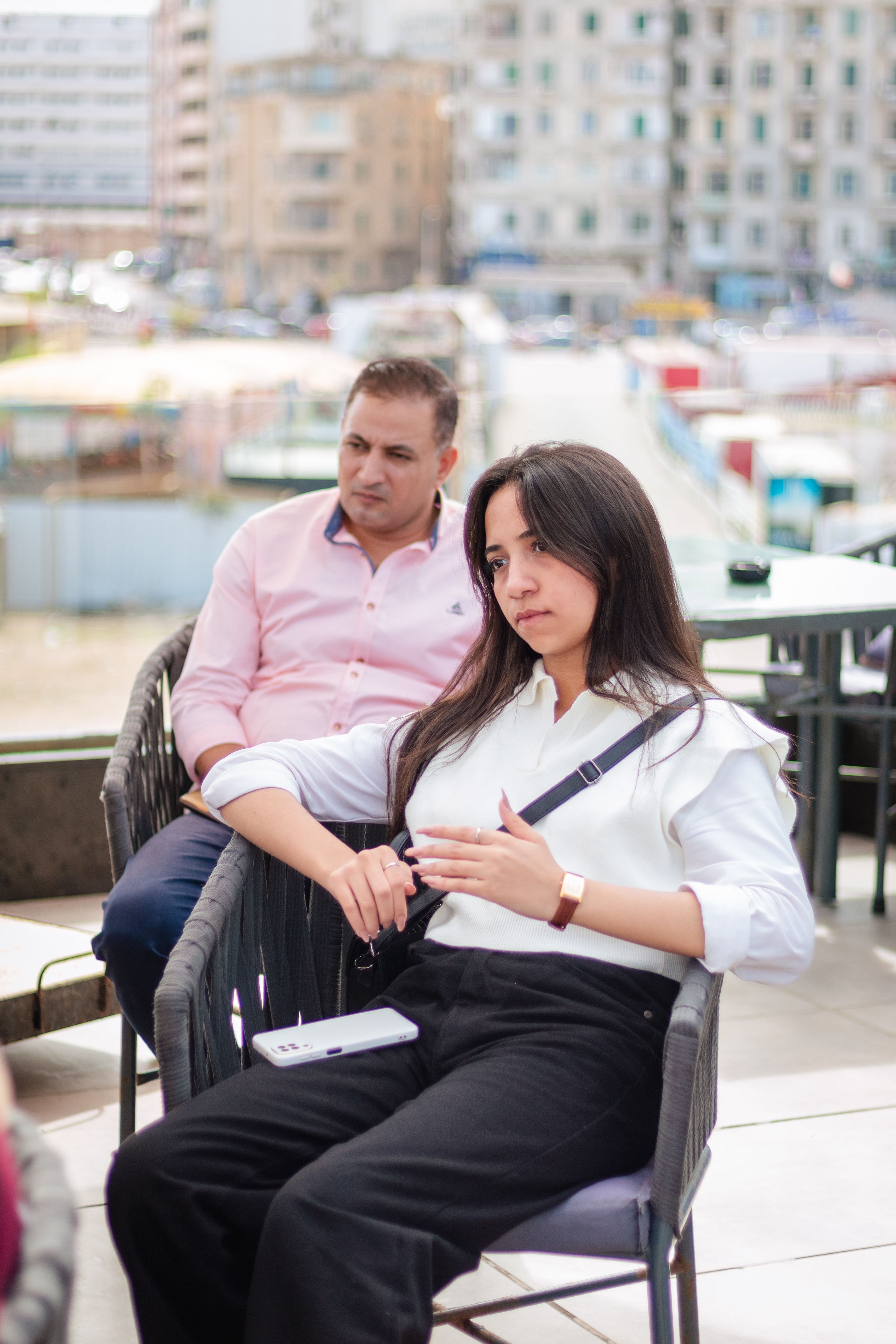A couple seated outdoors in Alexandria, Egypt, enjoying a relaxed moment together.