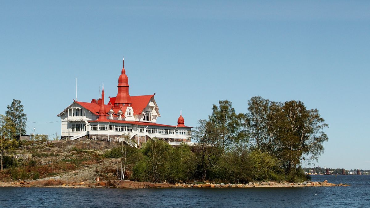 Beautiful red-roofed historic building on an island in Helsinki, Finland's coastline.