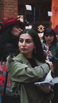 Fashionable woman walking through a bustling urban street, exuding confidence and style.