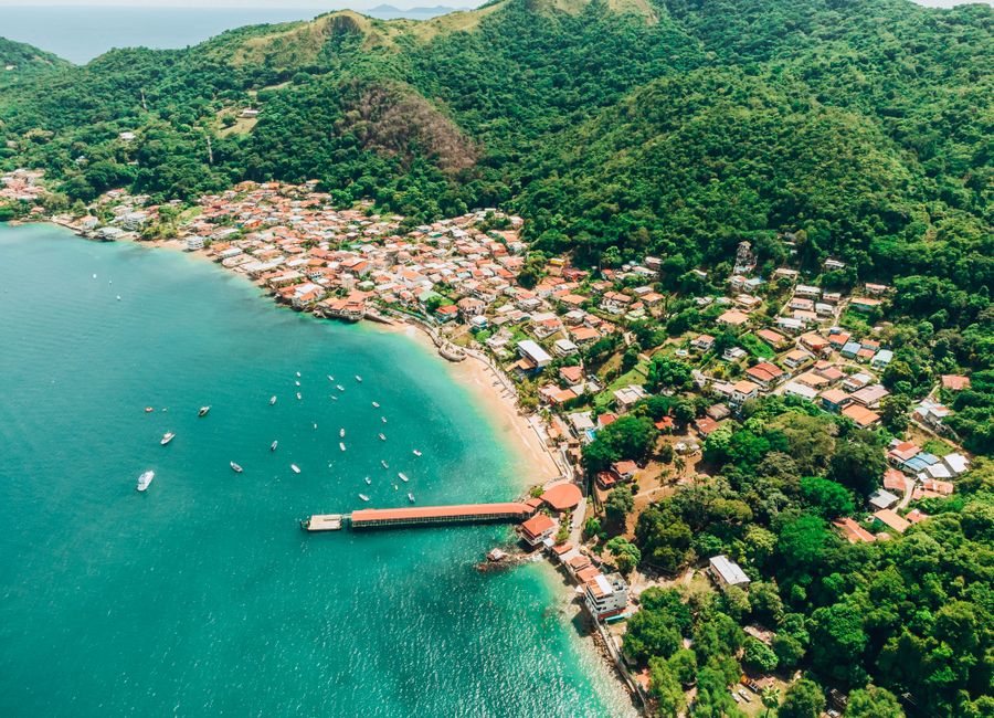A breathtaking aerial shot of Taboga Island's coastline, showcasing turquoise waters and lush hills.