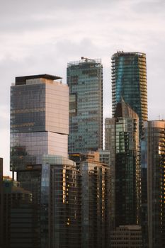 A striking view of modern skyscrapers in Vancouver with a moody cloudy sky backdrop.