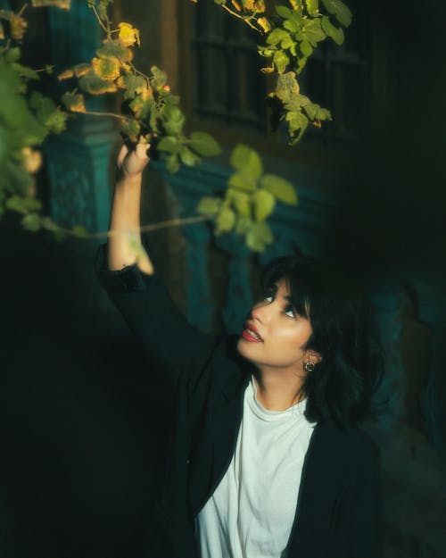 Portrait of Woman Looking at Shrub in a Garden 