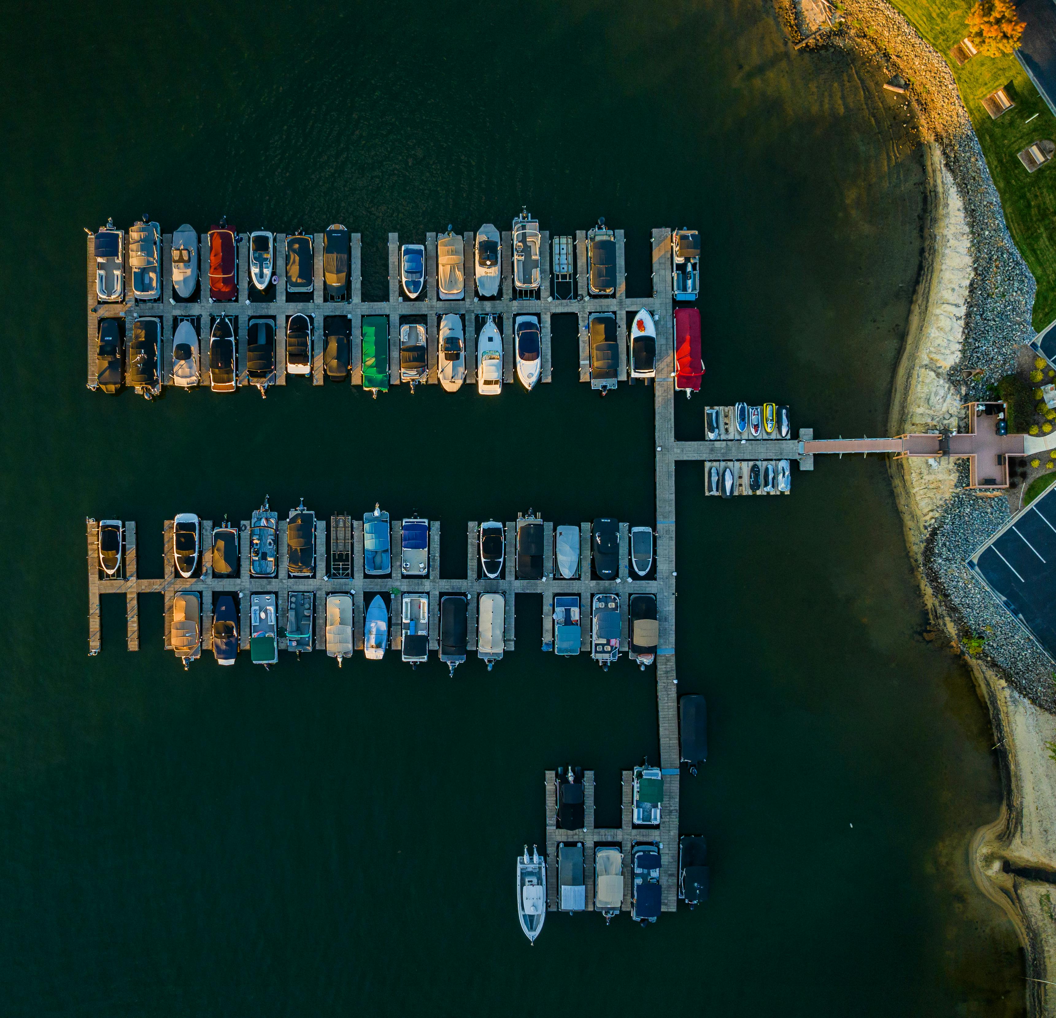 High-angle aerial shot of various boats docked at a marina, showcasing a vibrant arrangement of vessels.