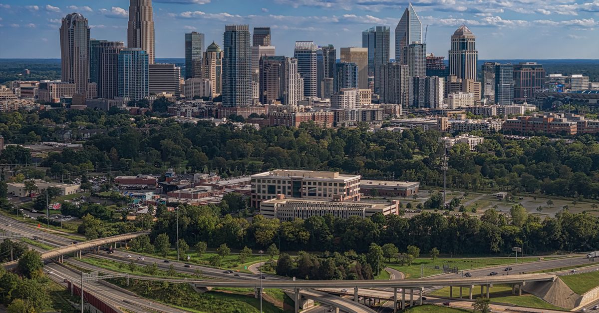 A vibrant view of Charlotte's modern skyline and highways on a sunny summer day.
