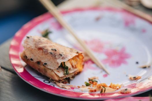 Delicious sesame seed wrap with chopsticks on a pink floral plate. Perfect for Asian cuisine lovers.