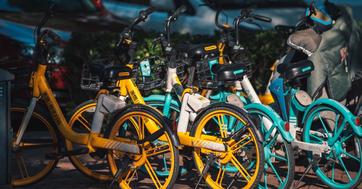 Brightly colored bikes parked in an urban area, highlighting a bike-sharing program.