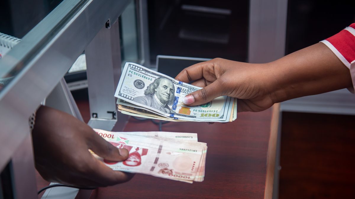 People exchanging different currencies by hand