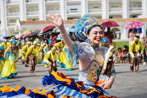Female Dancer Waving and Smiling During a Parade