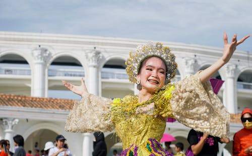 A Dancer in Traditional Clothing and Jewelry at a Festival 