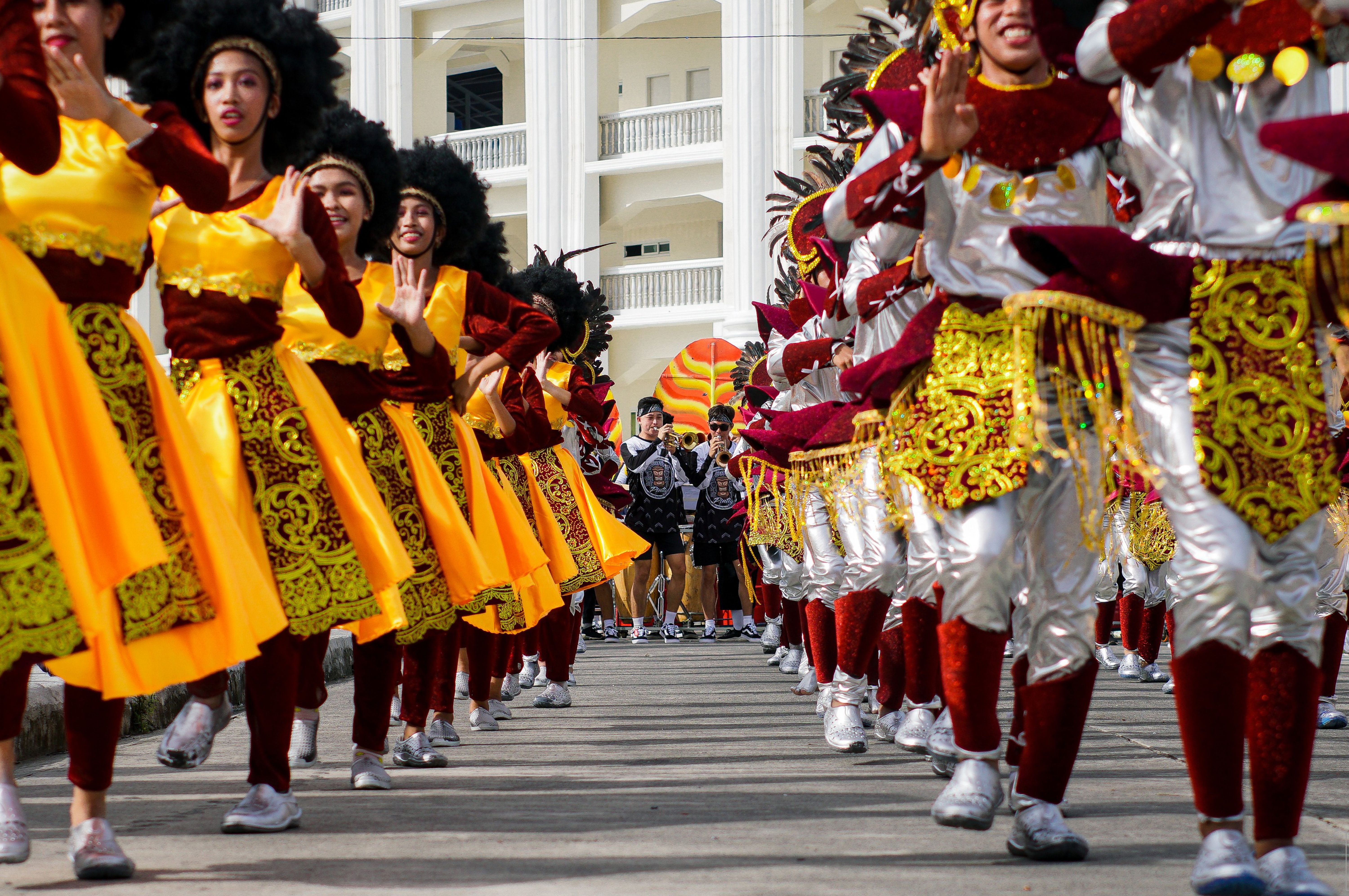 Minstrel troupe in bright satin marching through the city centre on a hot January morning