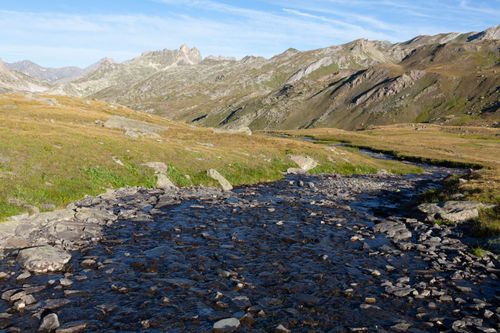 Free Flowing stream through rocky terrain in Névache, France under a clear sky. Stock Photo