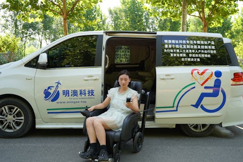 Woman in White Dress Sitting on Modern Wheelchair