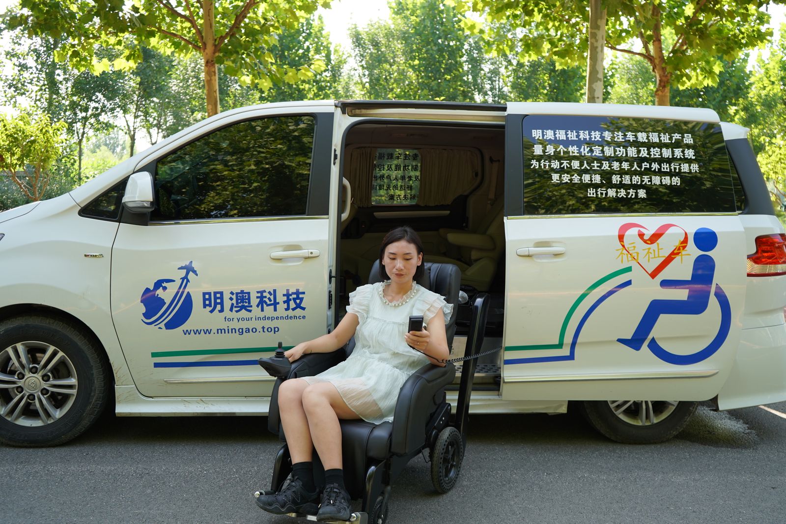 車いす利用者が福祉車両のそばでスマートフォンを確認する様子
