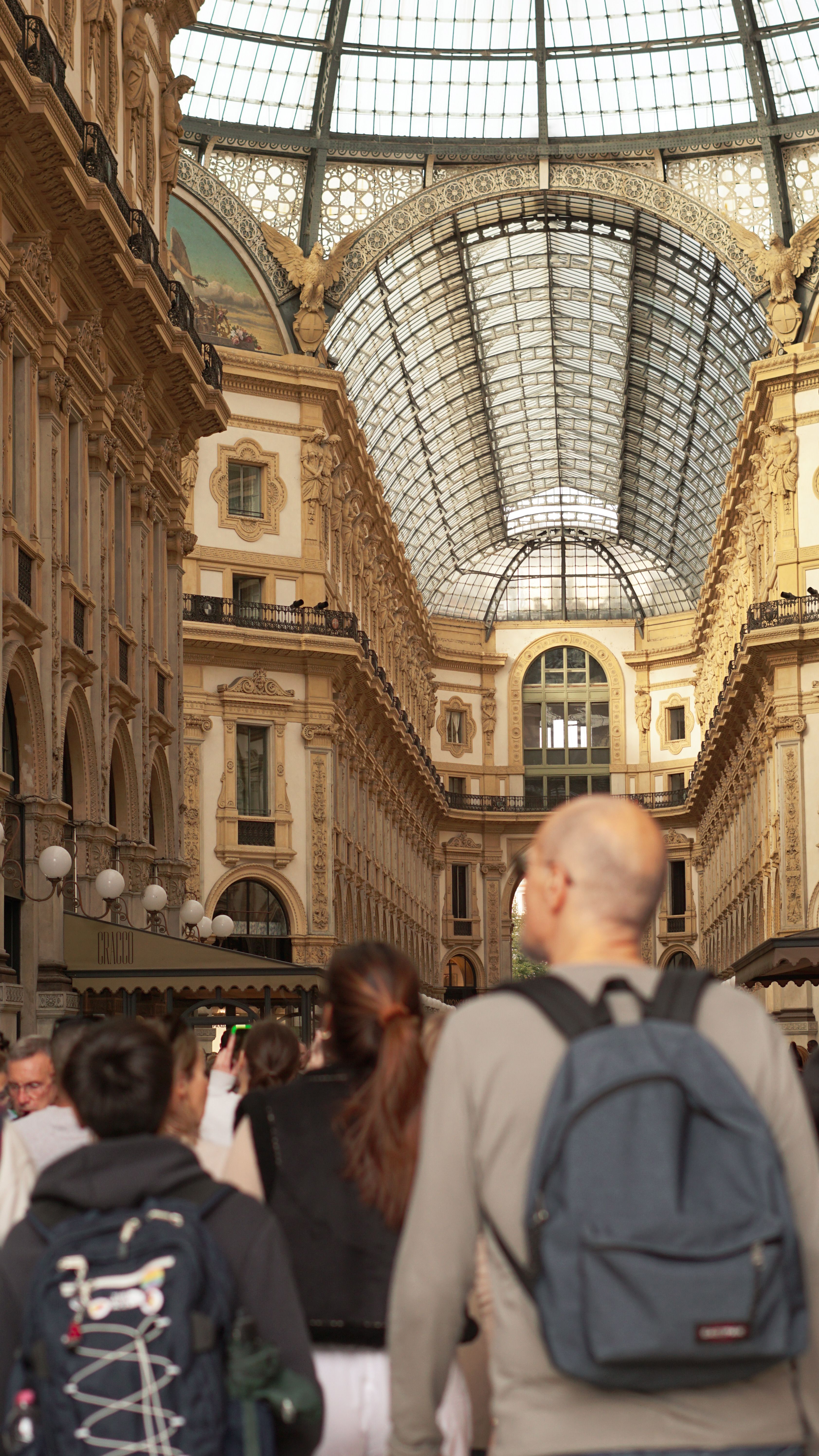 People exploring the historic Galleria Vittorio Emanuele II, Milan's iconic shopping arcade.