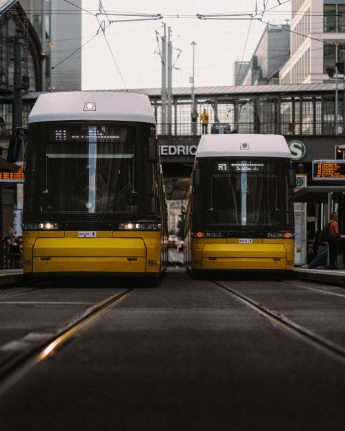 Free Two modern trams on a Berlin street, capturing urban life and public transportation. Stock Photo
