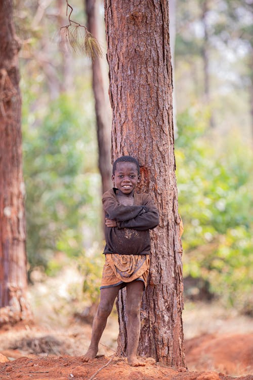Smiling Boy Standing by Tree