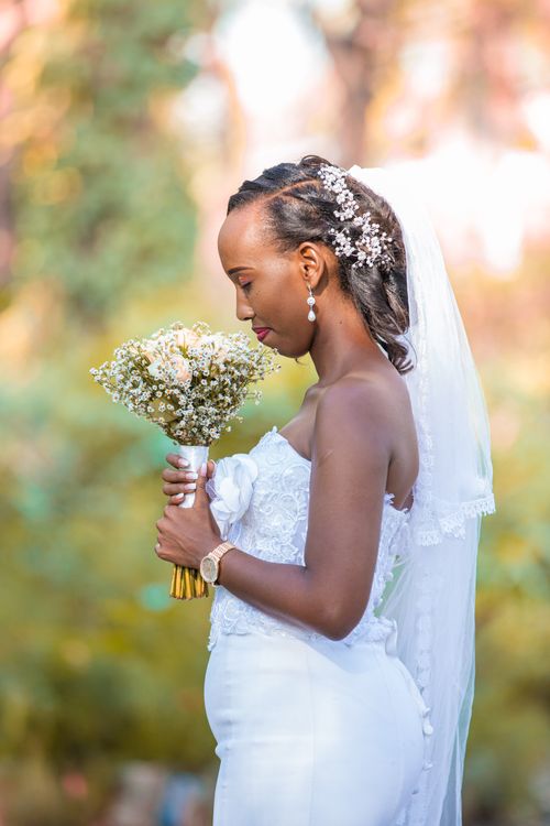 Free An elegant bridal portrait with a bouquet outdoors, showcasing fashion and grace. Stock Photo