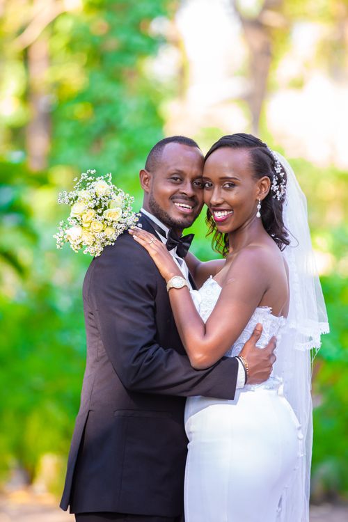 Free An elegant couple embracing on their wedding day in a lush garden setting. Stock Photo