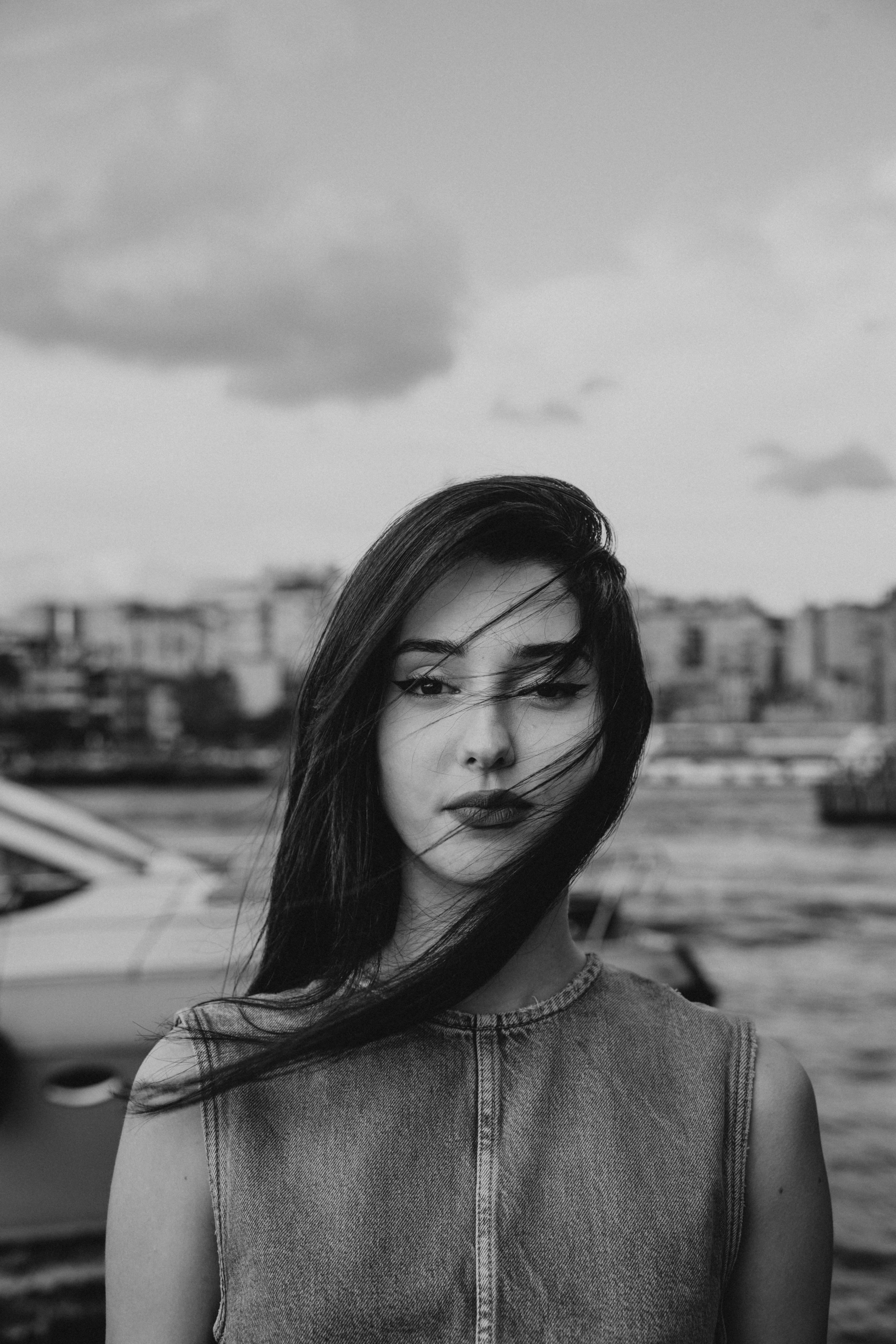 a woman with long hair standing in front of a boat